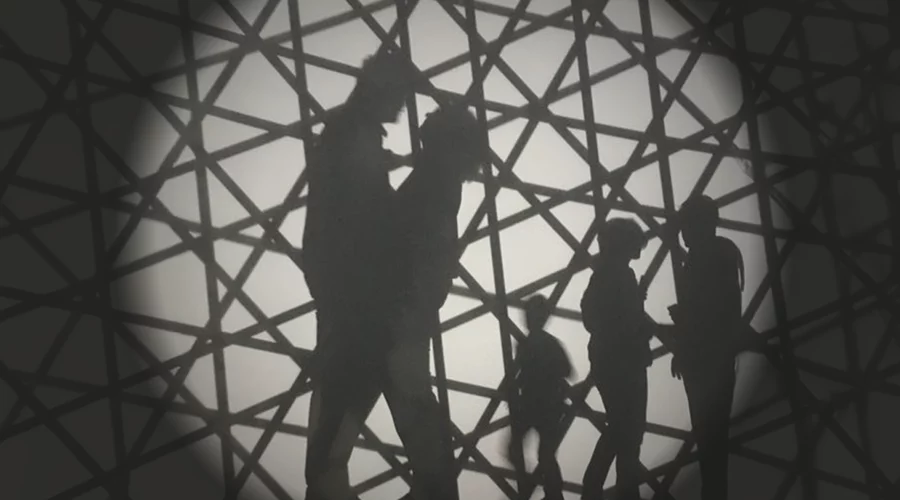 Photographie noire et blanc représentant une silhouette d’un couple heureux avec leurs enfants en arrière-plan, sur un fond à structure géométrique, illustrant la symbolique du lien familial et l’importance de la thérapie de couple pour éviter la séparation.